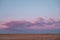 Pink clouds at sunset and desolate flat landscape, copy space for text.