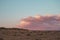 Pink clouds at sunset and desolate flat landscape, copy space for text.