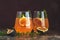 Pink cocktail with fig, thyme and ice in glass on dark wooden background, close up