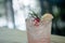 Pink cocktail with lychee syrup and sparkling soda decoration with rosemary cherries and slice lemon