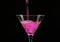 Pink cocktail poured into a glass on a dark background.