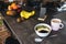 Pink coffee cup, chopped fruits in bowl and blueberries, spoon, phone in kitchen