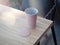 Pink coffee cup and coaster mockup lying on the wooden table, 3d rendering