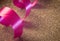 Pink color ribbon roll used in party decorations over glitter background. Party supplies