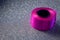 Pink color ribbon roll used in party decorations over glitter background. Party supplies