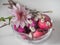 Pink colored glass vase with pink chrysanthemum and colored eggs
