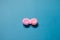 Pink contact lens case on blue background