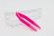 Pink contact lens tweezers on light background