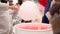 Pink cotton candy. Salesman are spinning the color of sugar with a spinning step