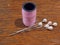 Pink Cotton reel and pearl pins on wood