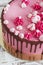 Pink cream cake meringues with smudges of chocolate on a white wooden background