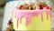 Pink cream sprinkling down tasty birthday cake