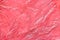 Pink crumpled polyethylene bag texture. Cellophane closeup