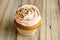 Pink cup cake on rustic wooden table close up