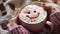 pink cup of coffee with pieces of chocolate and a smiley face on the foam in hands in a pink knitted sweater on a wooden