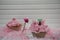 Pink cupcake decorated with a miniature person figurine holding a sign with words Spring Time and a cyclamen flower