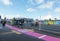 Pink cycle lane on footpath between bus stop and glass wall on the city`s Karangahape Road