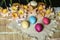 Pink daffodils and biscuits on burlap with painted Easter eggs lie on straw carpet