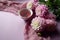 Pink dahlias lie on a light pastel background with a Cup of fragrant tea and a lilac napkin, close-up, side view, space for text