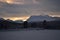 Pink dawn sky over frost ice and snowy winter forest and field