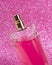 Pink delicate perfume spray bottle on fabric shiny background