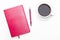 Pink diary with pen and a Cup of black coffee on white background.