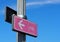 Pink directional sign. Female cycling symbol on blue sky background..