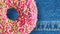 Pink Donut rotating on blue jeans background