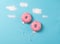 Pink donuts on blue background, creative food minimalism, donut in a shape of balloon in the sky with clouds made of sugar, top