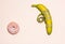 Pink doughnut and banana. Minimalism. Yellow banana wrapped in a centimeter tape. Located on the left, on a pale pink background.