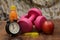 Pink Dumbbells with apple and clock fitness concept