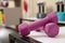 Pink dumbbells on white table indoors, closeup. Sports equipment