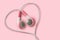 Pink earphones in heart shape on pink background - Concept of love, listening and support to women