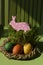 Pink Easter toy rabbit in a basket with colorful painted eggs Vertical