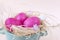 Pink eggs in a nest on a beige background, Easter , a dove, a plate