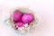 Pink eggs in a nest on a beige background, Easter, doves, plate, top view