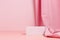 Pink empty podium with textile drape on pink background