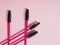 Pink eyelash brushes on a pink background with copyspace