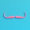 Pink fake mustache on bright blue background in pastel colors