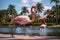 Pink flamingo on green lawn near exotic palms, summer