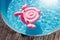 Pink flamingo inflatable ring in sunny pool