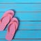 Pink flip flop sandals summer beach wood background