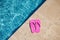 Pink flipflop on the granite poolside while vacation at the hotel