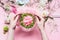 Pink Florist workspace with Lilies and other flowers, glass vase with water. Female hands making Festive Flowers arrangements