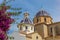 Pink flowers in front of the blue domes of the Altea church