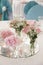 Pink flowers in small glass vases stand on the mirror on the wedding day