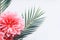 Pink flowers and tropical leaves on on white desktop background, top view, creative layout with copy space, border