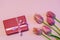 Pink fresh tulips and gift boxes on pastel paper background. Beautiful spring floral mock up. Greeting card for valentine`s, wome
