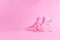 Pink Friday concept. Funny pink dinosaur toy with shopping cart full of present boxes on pink background