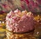 pink frosted cake sitting on gold background
